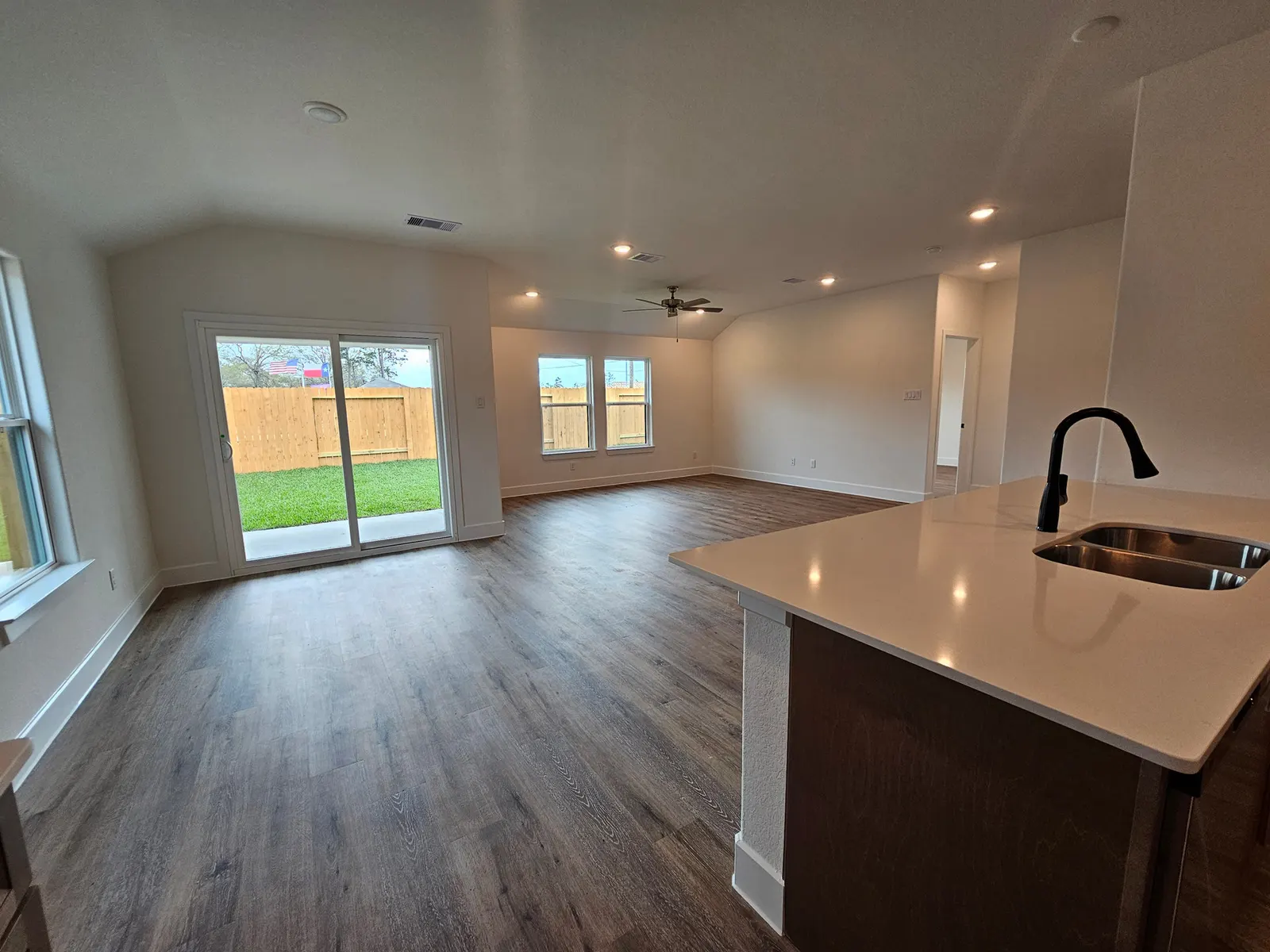 Living room with backyard windows open to the kitchen at 10727 Crockett Meadows, Conroe, TX