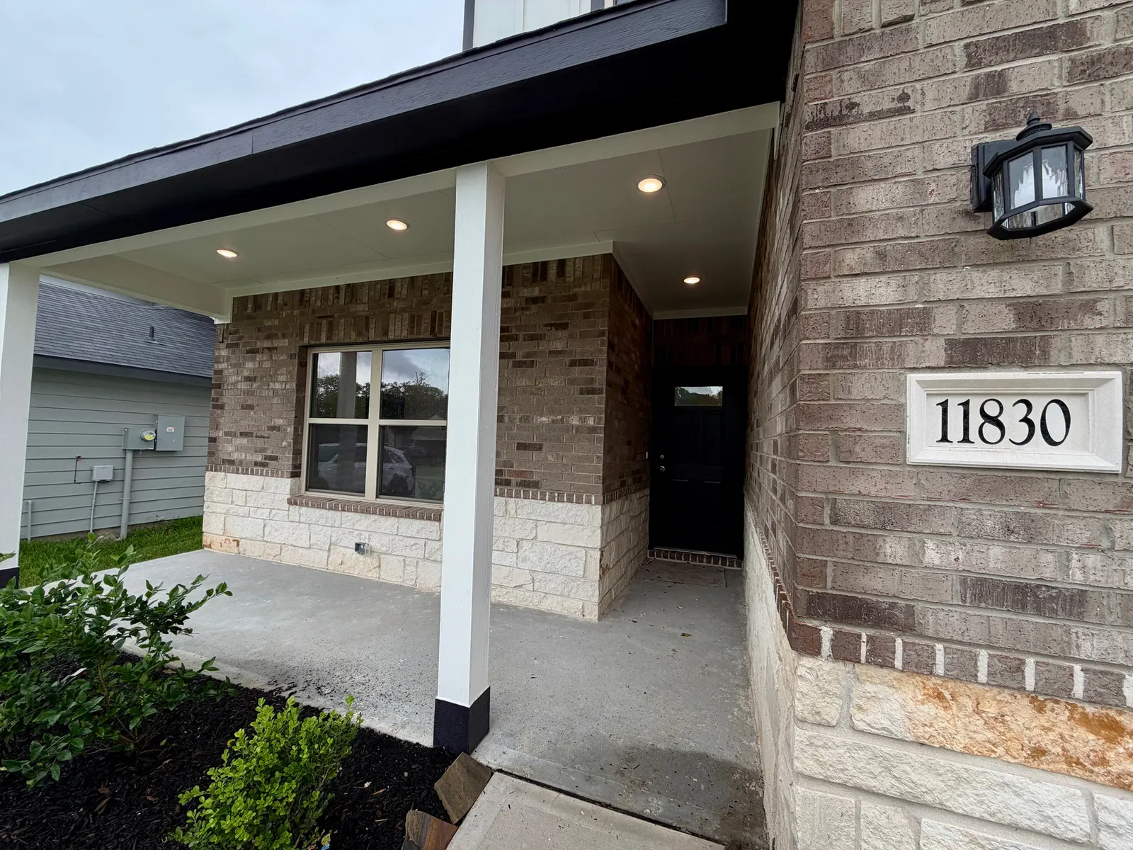 Covered front porch with brick columns at 11830 Serena's Song Drive, Willis, TX