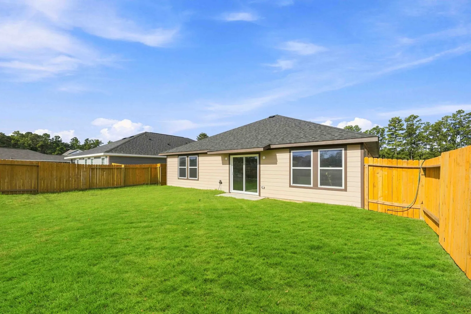 Rear exterior and fenced backyard at 10435 Sugar Mill Drive