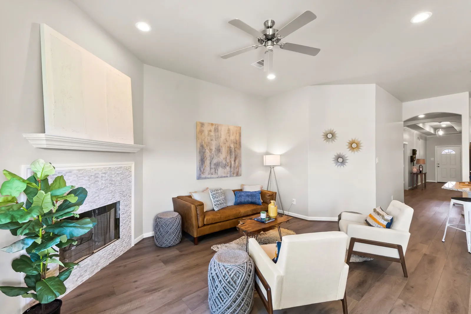 An Alta living room with a tiled fireplace, wood-look flooring, and an open view toward the entry